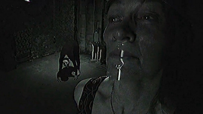 The Water Street Butcher creeps up on a victim whose mouth is covered with tape in "The Poughkeepsie Tapes" (2007)