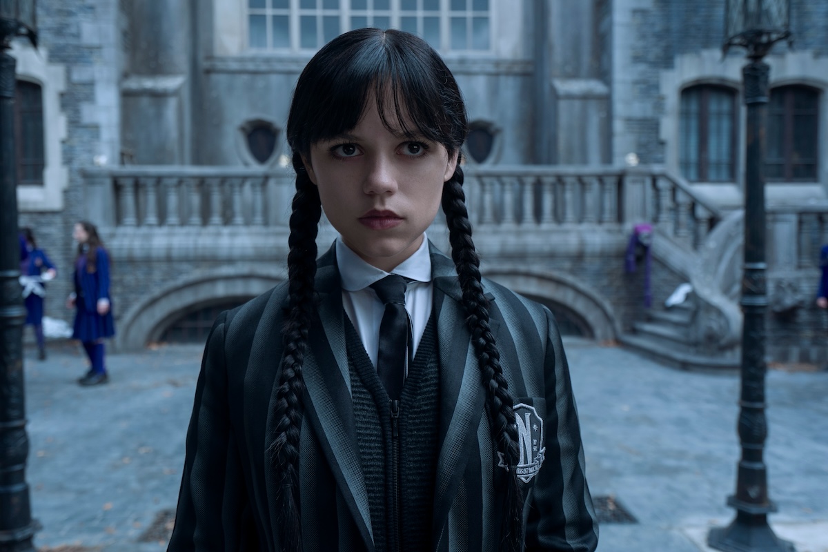 'Wednesday' actor Jenna Ortega stars as Wednesday Addams in Season 2 (shown wearing a black-and-white striped school blazer and pigtails, looking angry-bored)