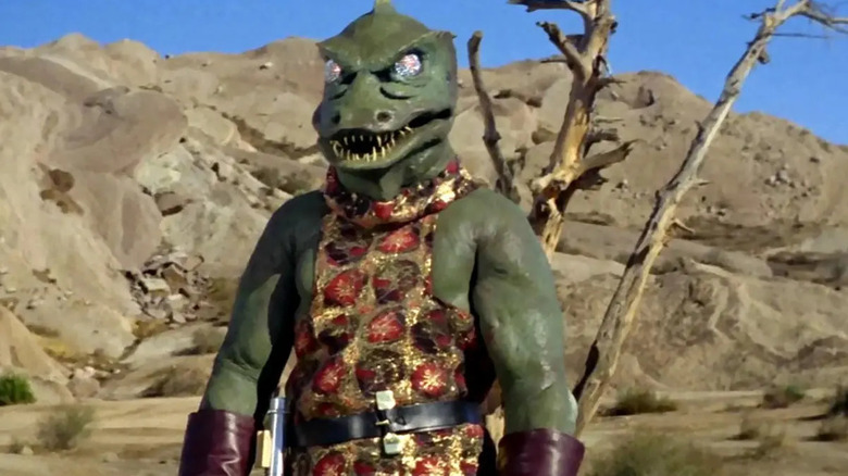 A Gorn awkwardly stands in front of some rocks in Star Trek