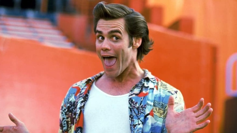 Ace Ventura smiles and waves his hands in "Ace Ventura: Pet Detective" (1994)