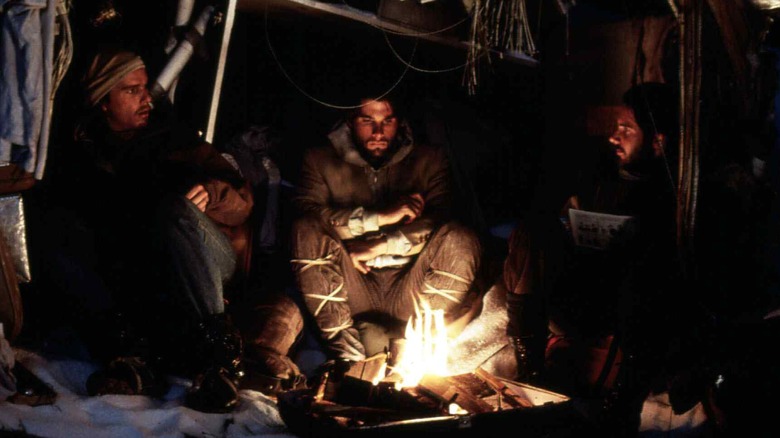 Nando, Roberto, and Javier sit around a fire in "Alive" (1993)