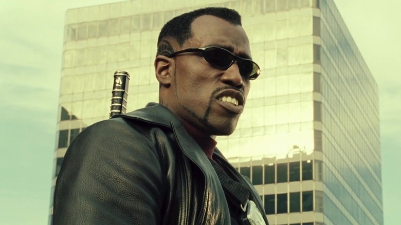 Blade scowling in front of a skyscraper