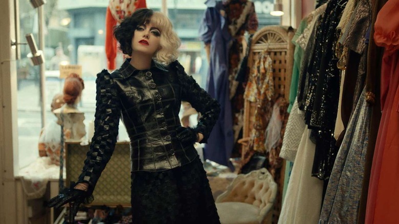Cruella stands in a clothing shop in "Cruella" (2021)