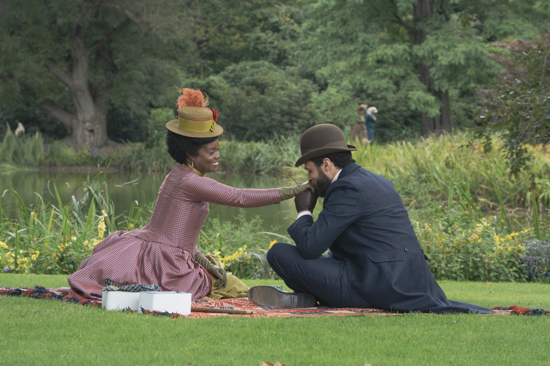 Denée Benton and Jordan Donica sitting in a park in Season 3 of 'The Gilded Age' 