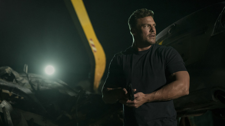 Reacher draws his gun on a night mission in "Reacher" (2022-present)