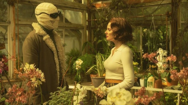 Larry (Matt Bomer) aka Negative Man and Rita (April Bowlby) aka Elasti-girl having an intimate conversation in a disheveled greenhouse on "Doom Patrol"