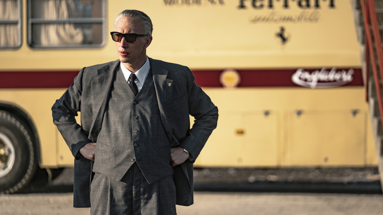 Enzo Ferrari watches a race in "Ferrari" (2023)