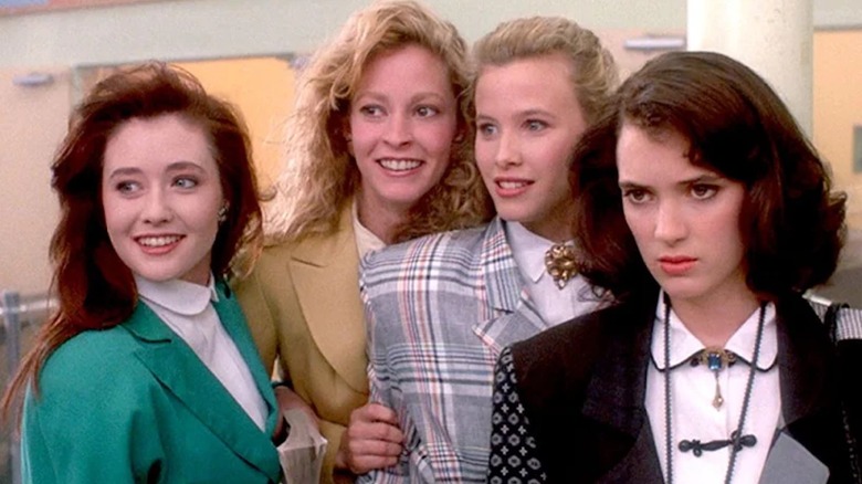 Veronica scowls as the Heathers smile in Heathers (1988)