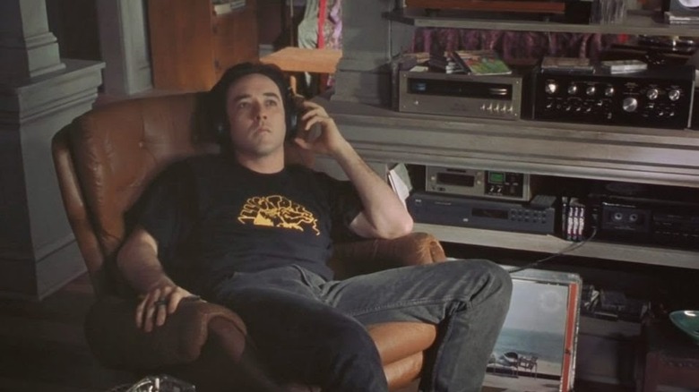 Rob listening to records with his headphones on in High Fidelity