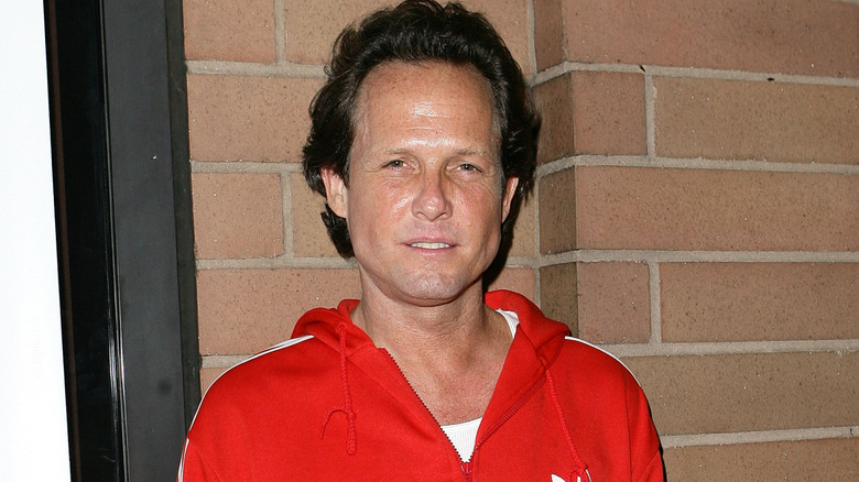 Dean Winters wearing a red Adidas tracksuit jacket in 2010