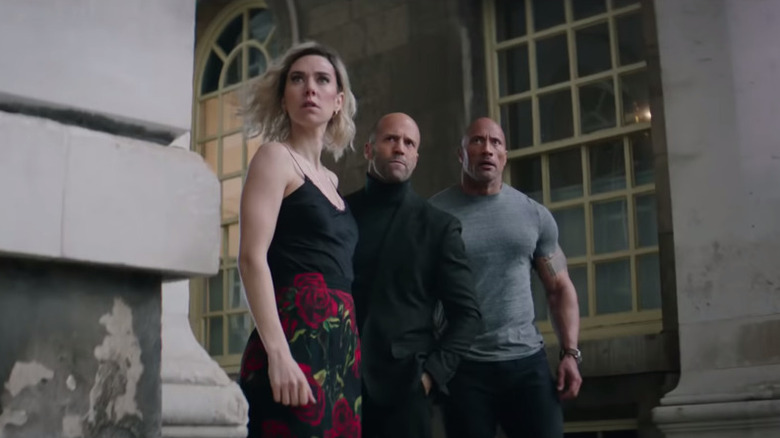 Hobbs, Shaw, and Hattie turn a corner and look around in "Hobbs and Shaw" (2019)