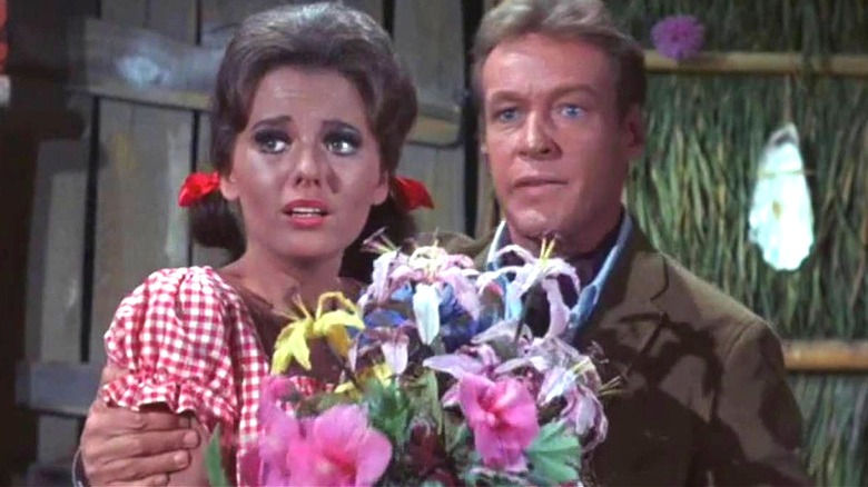 The Professor hugs Mary Ann Summers as she holds some flowers