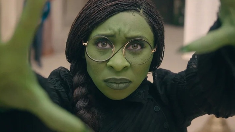 Elphaba stretches out her arms in "Wicked" (2024)