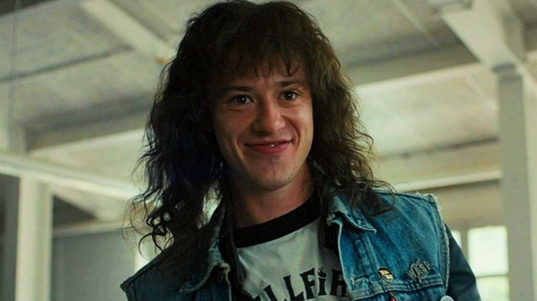 Eddie Munson smiling in the school cafeteria in "Stranger Things" (2016-present)