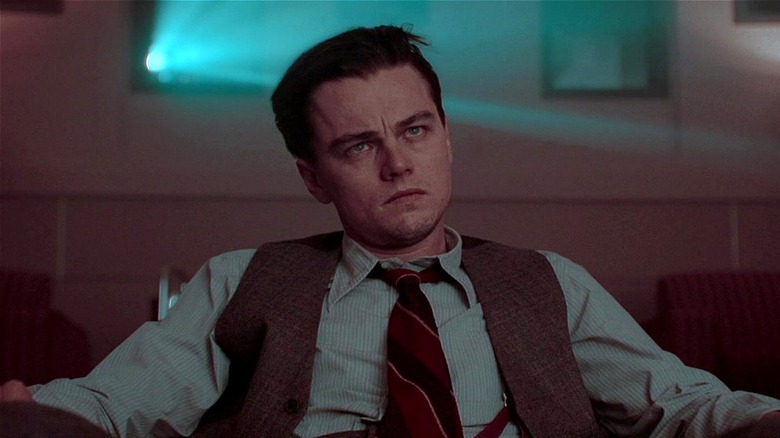 Howard Hughes looking serious while watching his movie in The Aviator