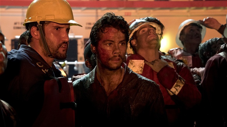 Caleb Holloway looking dazed standing with other workers in "Deepwater Horizon" (2016)