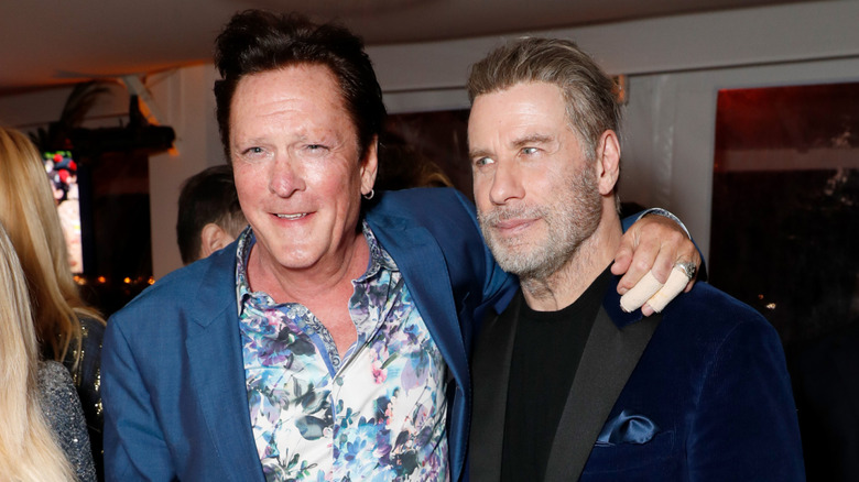 Madsen and John Travolta embrace at a public event.