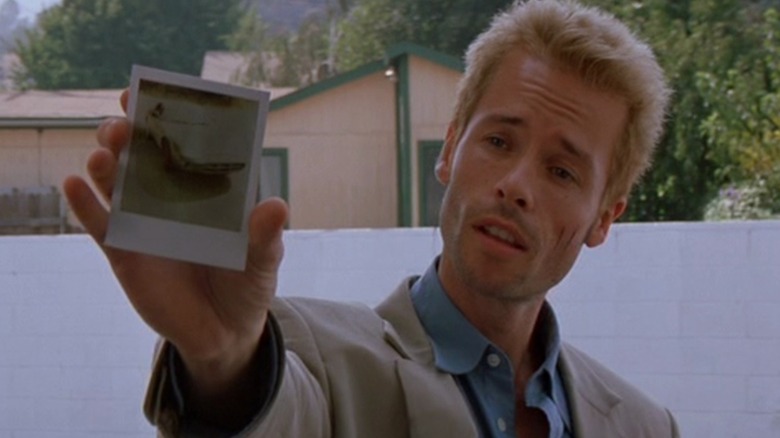 Leonard holding up a Polaroid photo in "Memento" (2000)