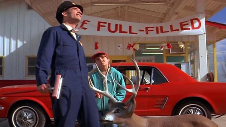 Gus leaning against his red Mustang in Motorama