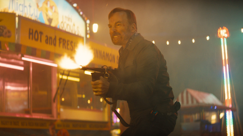 Hutch shooting a gun at a carnival in Nobody 2