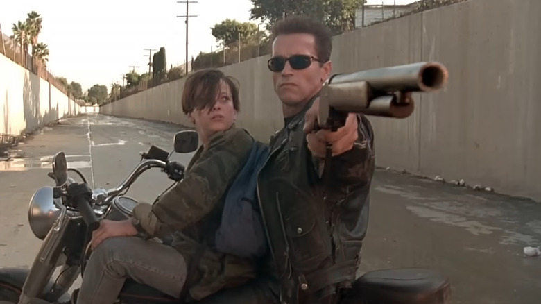 The T-800 points his gun on a motorcycle with John Connor in "Terminator 2: Judgment Day" (1991)