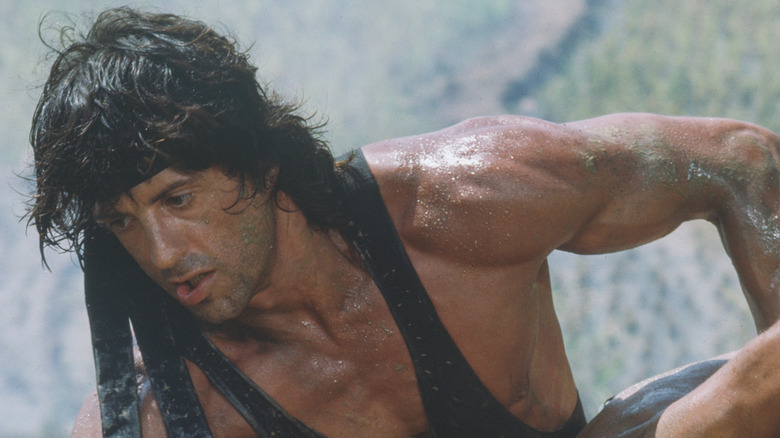 Rambo wrestles a man to the ground in "Rambo: First Blood Part II" (1985)