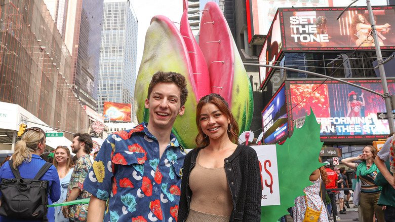 Andrew Barth Feldman and Sarah Hyland smiling at the "Little Shop of Horrors" installation in New York in 2024