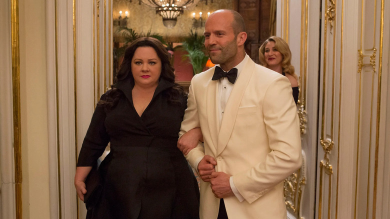 Cooper enters a ballroom with Ford on her arm in Spy (2015)