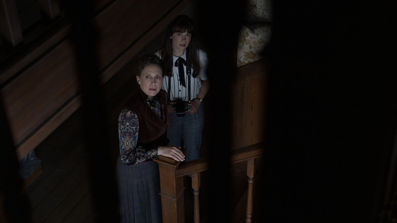 Judy and Lorraine nervously peering up in "The Conjuring: Last Rites" (2025)