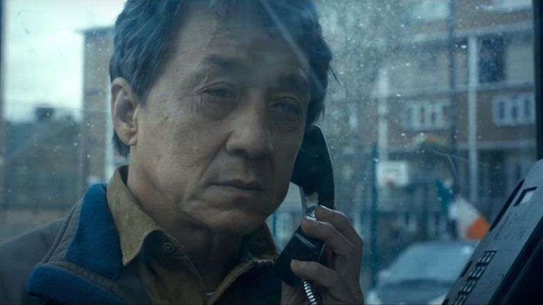 Minh makes a call in a phone booth in "The Foreigner" (2017