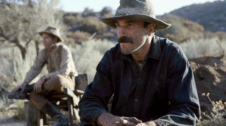 Daniel sits outside wearing a hat in "There Will Be Blood" (2007)