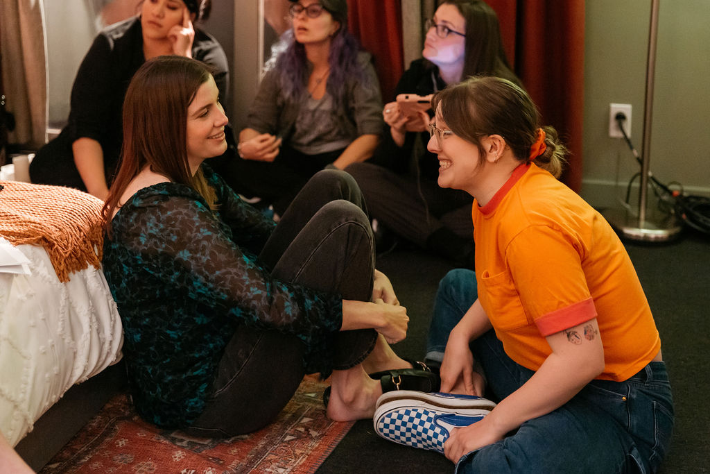 Izzy Roland and Vic Michaelis sitting in a bedroom behind the scenes of 'D(e)ad' 