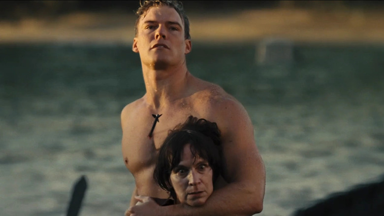 Gloss holding Wiress with an arrow in his chest in "The Hunger Games: Catching Fire" (2013)