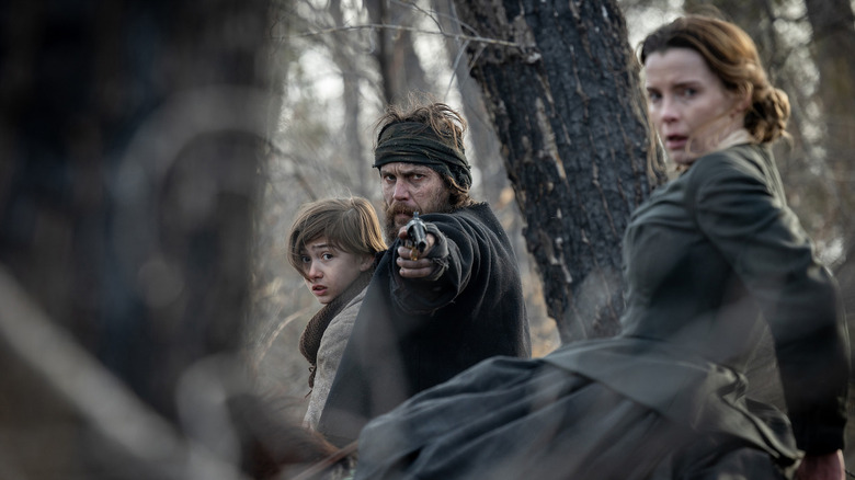 Isaac aims a gun past Sarah on American Primeval
