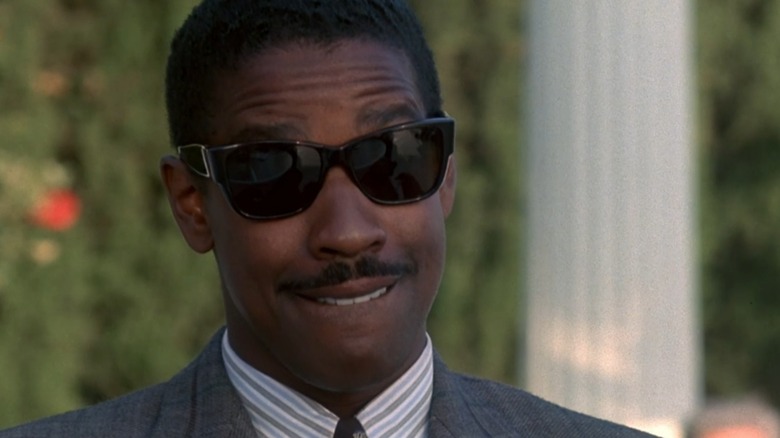 Napolean Stone wearing sunglasses and biting his lip in "Heart Condition" (1990)
