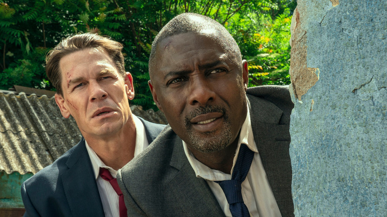 Will Derringer and Sam Clarke peer out from behind a wall in "Heads of State" (2025)