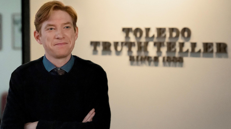 Editor-in-chief Ned Sampson (Domhnall Gleeson) standing in front of a wall sign that reads "Toledo Truthteller"