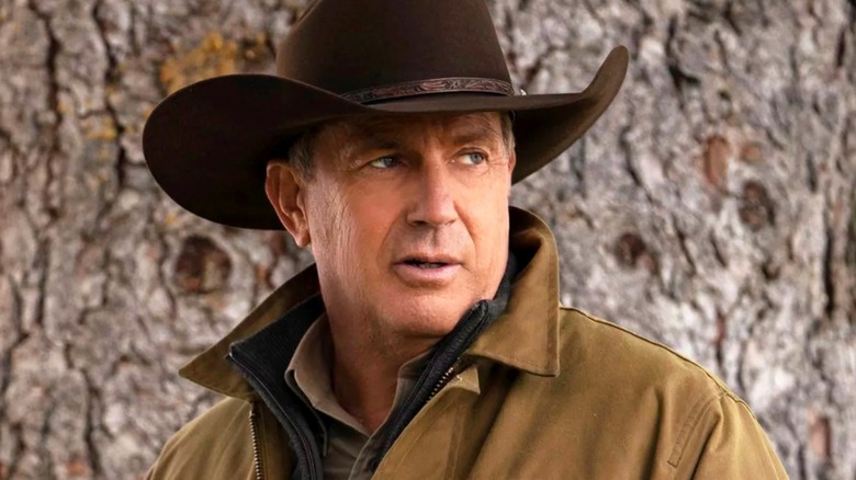 John Dutton standing in front of a tree in Yellowstone