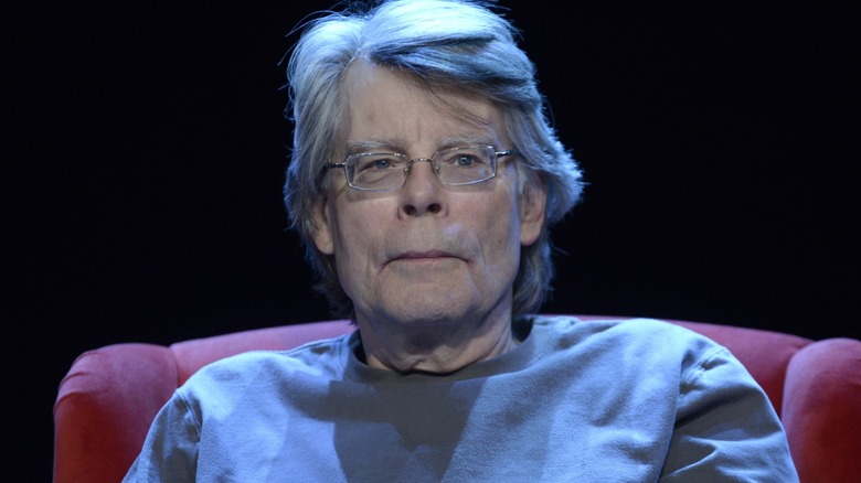 Stephen King seated in a red chair on a stage
