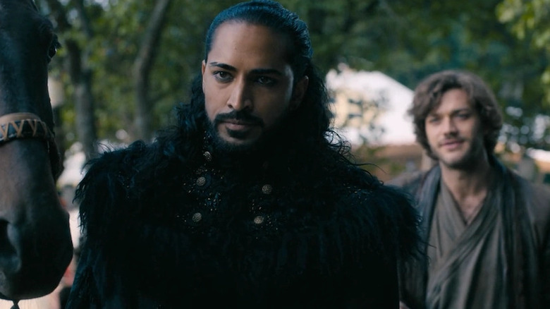 Ahmad stands in a black fur outfit looking serious on Marco Polo