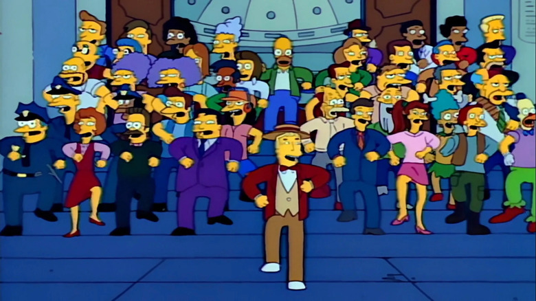 Lyle Lanley leading Springfieldanites in a "Monorail!" performance in "Marge vs. the Monorail" (1993)