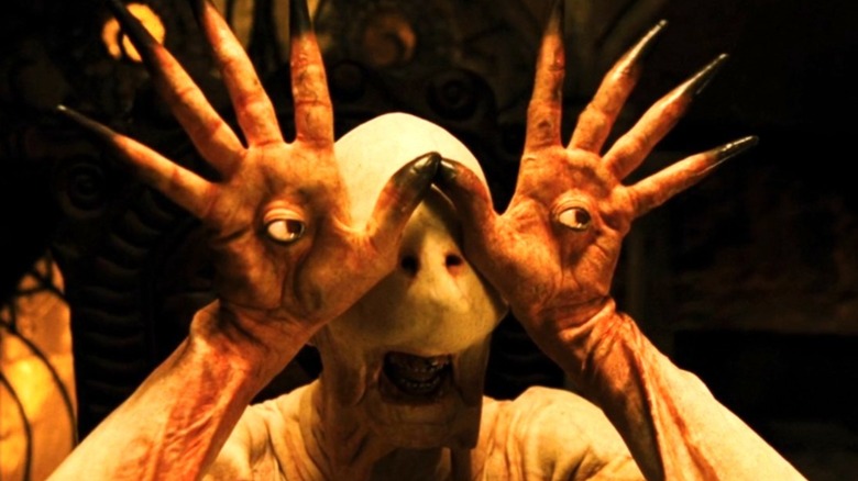 The Pale Man holds up his hands, which are embedded with his eyes, in Pan's Labyrinth (2006)