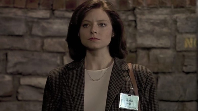 Starling standing in front of a stone wall in "The Silence of the Lambs" (1991)