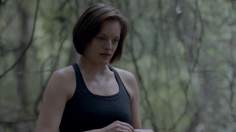 Griffin stands in the woods, looking down in "Top of the Lake" (2013-2017)