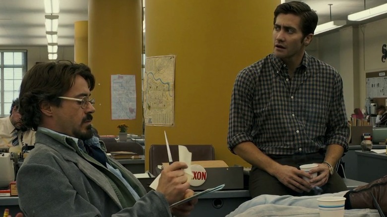 Graysmith talking to a seated Avery in "Zodiac" (2007)